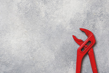 Red key for pipes and other metal products on a gray background. Copy space.