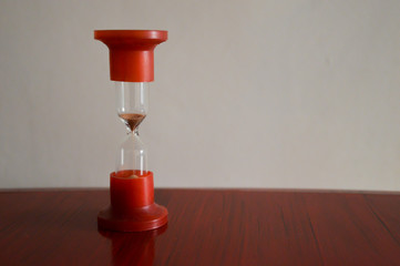 red hourglass on wooden background