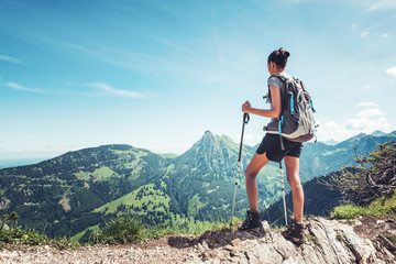 Wall Mural - Fit female hiker standing on a mountain ridge