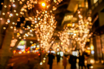 Wall Mural - Blurred and bokeh of LED refection lighting on trees after Christmas and New Year with city night life in Osaka, Japan.