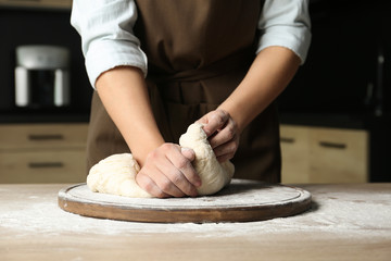 Female baker preparing bread dough at table, closeup