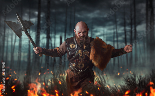 Fotografía Angry viking with axe, battle in forest