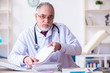© Elnur - Old male doctor working in the clinic
