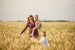© oes - Family values. Happy mother and her children spending time together in sunny field. Mom hugging and loving her little kids. Care concept