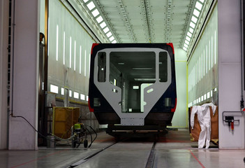 Wall Mural - Inside of the rail car assembly plant. Industrial workshop for the production of European high speed trains. Painting a train at the Stadler Minsk rolling stock plant