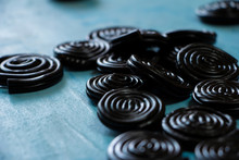 Detail Of Licorice Candy Spirals On Blue Background