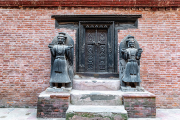 Wall Mural - Wooden carved entrance door with carved statues on sides at Durbar Square, Bhaktapur, Kathmandu Valley, Nepal.