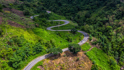 Wall Mural - Aerial view road in mountains, Road running through green hills forest with car.