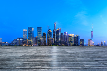 Shanghai skyline and modern city skyscrapers with wooden board square at night,China