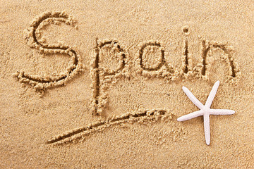 Spain word written in sand on a sunny spanish summer beach with starfish holiday vacation travel destination sign writing message photo