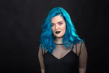 Canvas Print - Style and fashion concept - Young and attractive woman with blue hair posing over black background