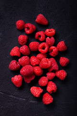 Wall Mural - top view, on a black and rustic background, some fresh raspberries.