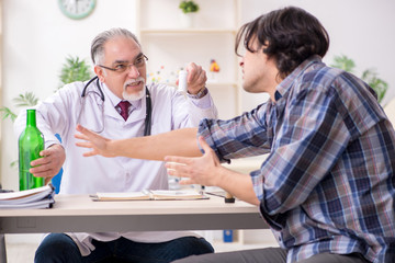 Young male alcoholic visiting old doctor  