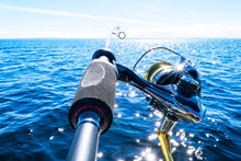 Fishing Rod Spinning With The Line Close-up. Fishing Rod In Rod Holder In Fishing Boat Due The Fishery Day. Fishing Rod Rings. Fishing Tackle. Fishing Spinning Reel.