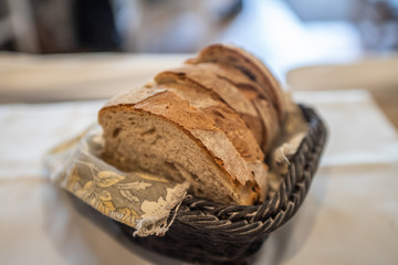 Homemade bread cut into slices in a wicker basket.