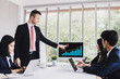 © khwanchai - Group of business people meeting and planning with financial graph in meeting room