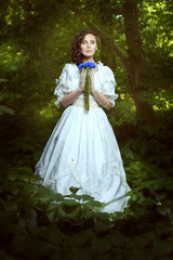 Fantastic girl in a white dress with flowers cornflowers.