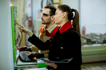 Attractive young female technician carrying out inspection at production department of plant