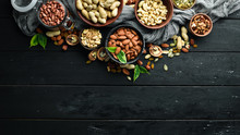 Assorted Nuts On The Old Black Background. Top View. Free Space For Your Text.