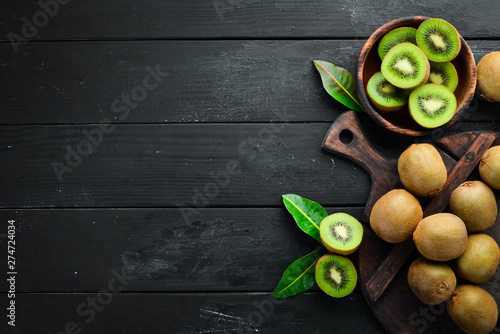 Photographie Fresh kiwi and green leaves on the table