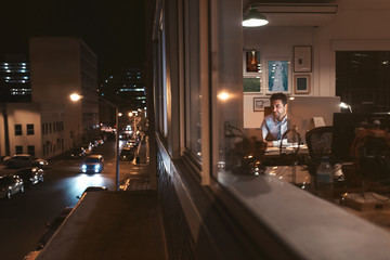 Young businessman working inside of an office at night