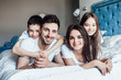 © Тарас Нагирняк - Happy smiling young family with kids lying in bed, portrait in bedroom.