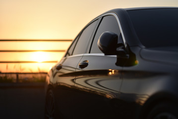 Side of a luxury car parked in the parking lot of a business center. Selective focus on door handle