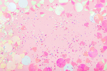 Colorful Confetti and sparkles on pink pastel trendy background. Festive frame, holiday backdrop. Flat lay, copy space.