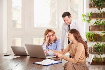 Teamwork in the office. Group of business people working together on laptop in the office