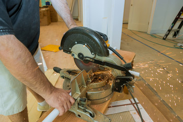 Craftsman sawing metal with disk grinder in workshop.