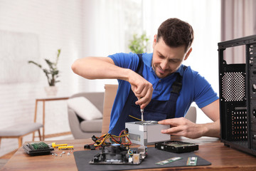 Canvas Print - Male technician repairing power supply unit at table indoors