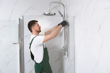 Wall Mural - Professional handyman working in shower booth indoors