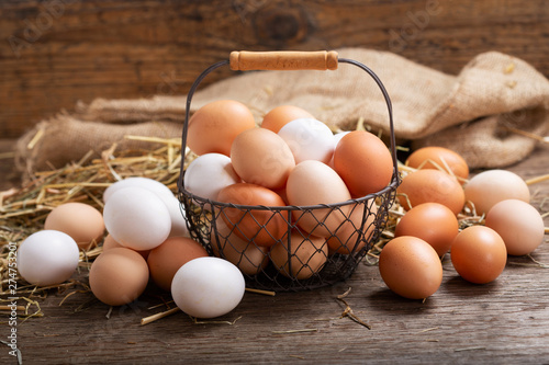 Fotografía basket of colorful fresh eggs on wooden table