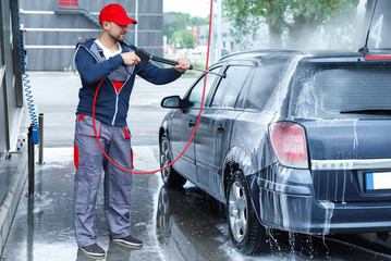 Wall Mural - Car wash worker is washing client's car