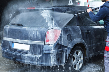 Wall Mural - Car wash worker is washing client's car