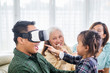 © Creativa Images - Happy man wears a VR headset with his family