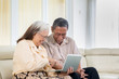 © Creativa Images - Old couple looks happy with laptop at home