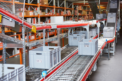 Fotografía Automated warehouse. Boxes with spare parts moving on conveyer