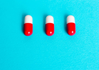 White red capsules, pills on a blue background.