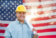 © Andy Dean - Hispanic Male Contractor with Blueprint Plans Wearing Hard Hat In Front of American Flag