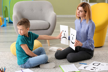 Wall Mural - Female psychologist working with boy suffering from autistic disorder