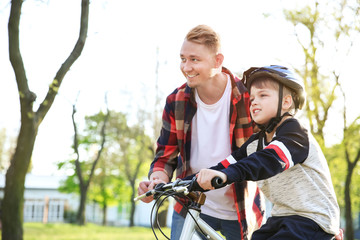 Sticker - Father teaching his son to ride bicycle outdoors