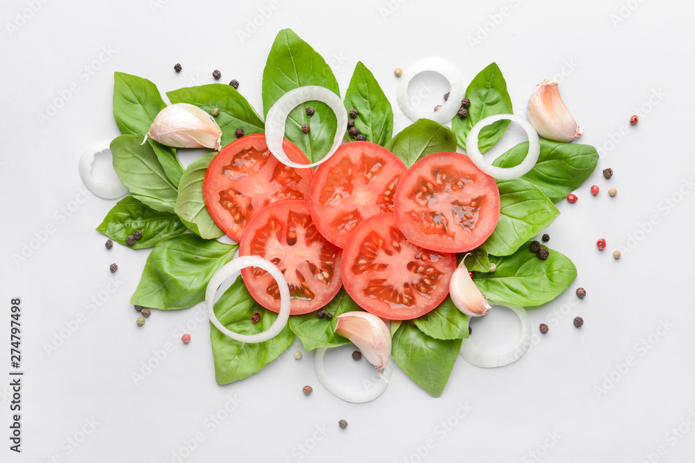 Fresh basil, tomato and spices on light background