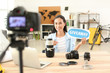 © Pixel-Shot - Female Asian blogger announcing giveaway while recording video at home