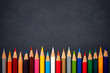 © Sainam - Colored pencils on chalkboard background. Top view and copy space. Concept of art education.