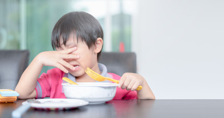 asian child boy eating boring food in morning