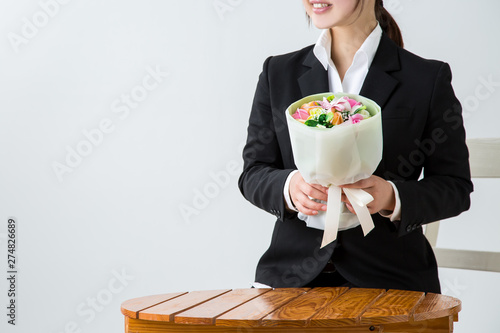 白背景にスーツを着た女性が花束を持って笑顔で座っている Stock Photo Adobe Stock 白背景にスーツを着た女性が花束を持って笑顔で座っている Stock Photo Adobe Stock