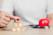 © A Stockphoto - Health Insurance Concept,hand arranging wood block stacking with icon healthcare medical.