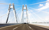 Fototapeta Most - Sunspension bridge with empy road on the blue sky.