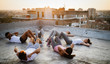 © NDABCREATIVITY - Group of fit healthy friends, people exercising together outdoor on rooftop
